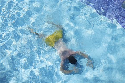 Hombre En La Piscina Flotando En El Agua Sobre El Vientre Buceando En