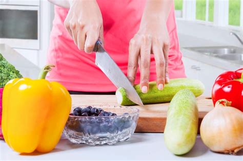 Premium Photo Woman Hands Cutting Fresh Cucumber