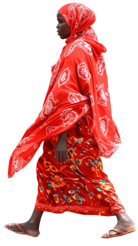 African Rural Woman In Traditional Attire Walking Away Carrying A