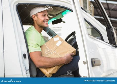 Smiling Delivery Driver In His Van Holding Parcel Stock Image Image