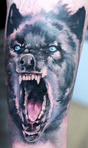 A Tattoo With An Image Of A Wolf On It S Leg Showing Its Teeth