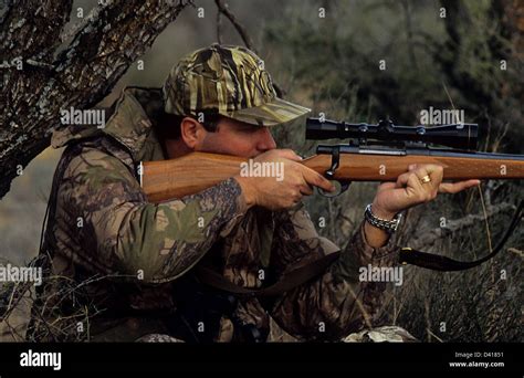 A South Texas Deer Hunter Looking Through His Scope And Aiming A Rifle