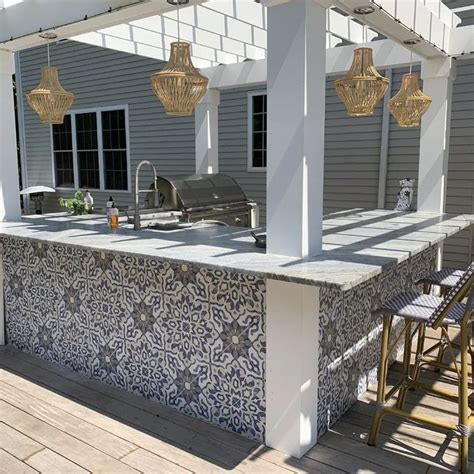 An Outdoor Kitchen And Grill Area On A Deck