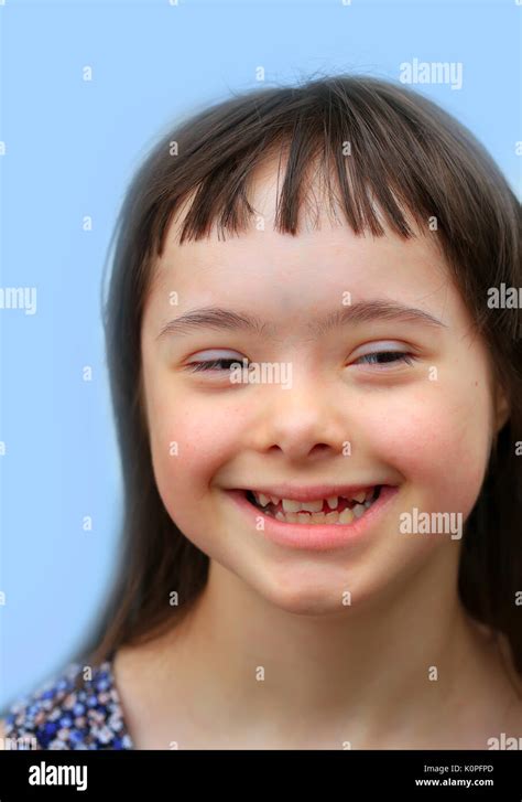 Cute Smiling Down Syndrome Girl On The Brown Background Stock Photo Alamy