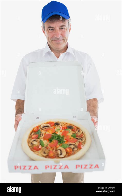 Portrait Of Mature Delivery Man Holding Pizza Against White Background