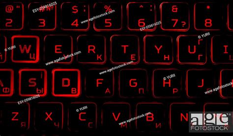 Black computer keyboard with red backlight in the dark. Laptop keyboard ...