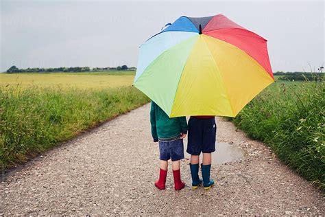 "Children Walking On A Rainy Day With A Rainbow Umbrella" by Stocksy ...