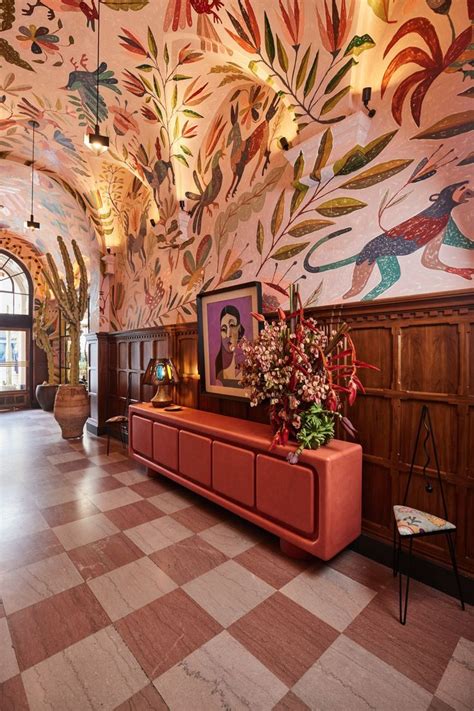 An Ornately Decorated Lobby With Red Couches And Paintings On The Walls