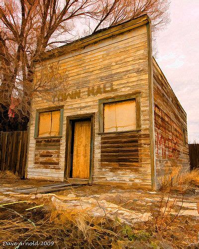 an old run down wooden building sitting next to a tree