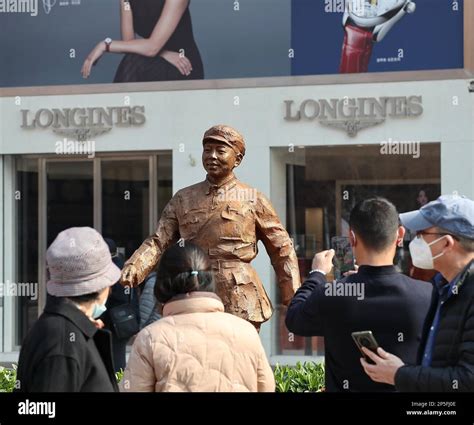 People take photos in front of the bronze statue of Lei Feng, a Chinese soldier who died in 1962 ...