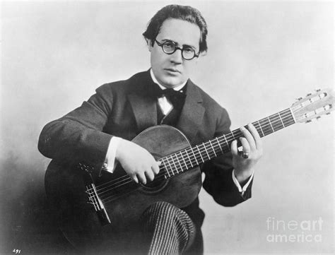 Andres Segovia Seated Holding Guitar by Bettmann