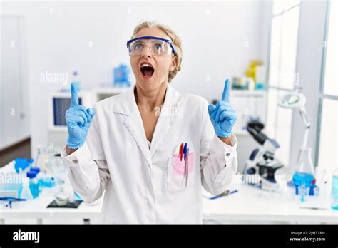Middle Age Blonde Woman Working At Scientist Laboratory Amazed And