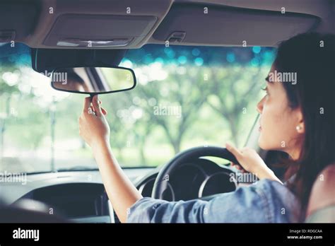 Asian Women Are Adjusting The Rearview Mirror Of The Car Stock Photo