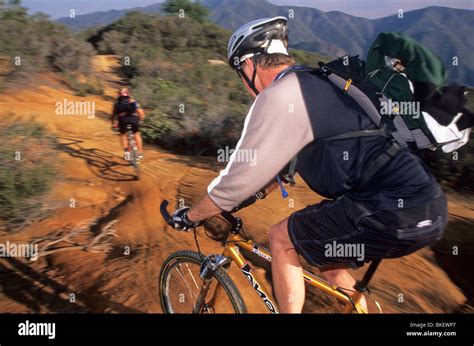 Two Men Mountain Biking Stock Photo Alamy