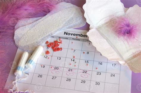 Menstrual Pads And Tampons On Menstruation Period Calendar With On Lilac Background 36037848