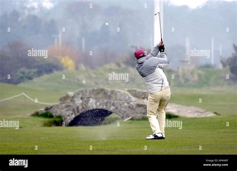 Golfer Taking A Shot Over The Swilcan Bridge On The Old Course St