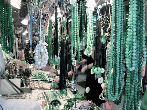 A Woman Is Looking At Necklaces On Display In A Store Window With Green