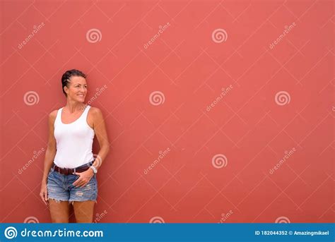Happy Mature Beautiful Tourist Woman Thinking Against Pink Wall Stock