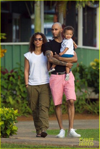 A Man And Woman Walking With A Baby In Their Arms