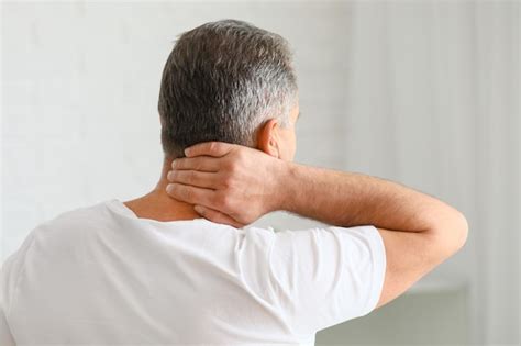 Premium Photo Mature Man Suffering From Neck Pain At Home