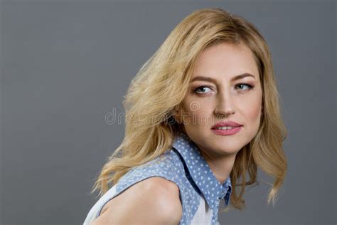 Close Up Studio Portrait Of A Beautiful Middle Aged Blonde Woman Gray