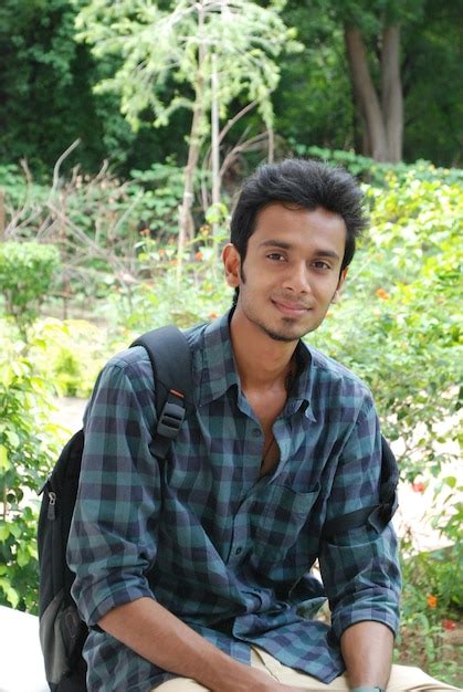 Premium Photo Portrait Of Young Man Sitting Against Plants