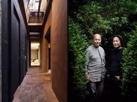 Two Men Standing Next To Each Other In Front Of A Green Wall And Stairs