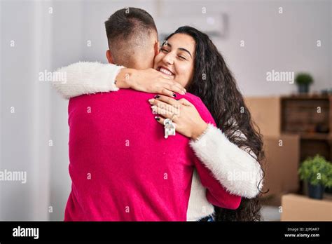 Man And Woman Couple Hugging Each Other Holding Key At New Home Stock