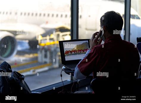 Traveling Businessman Working With Laptop And Using Smartphone In The