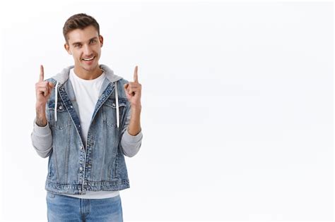 Portrait d un bel homme gay élégant souriant pointant les doigts vers le haut Photo Gratuite