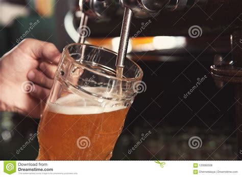 Cerveza De Colada Del Camarero Del Golpecito En El Vidrio En Barra Foto