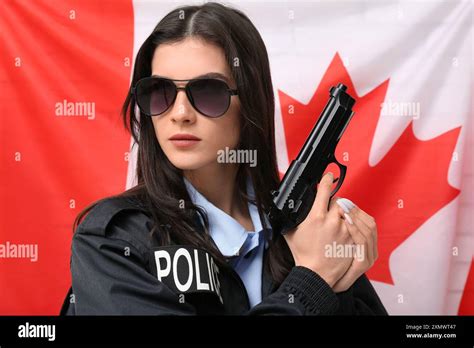 Female Police Officer With Gun Against Flag Of Canada Stock Photo Alamy