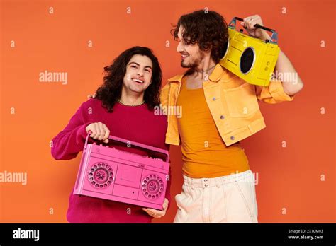 Two Cheerful Attractive Gay Friends In Vibrant Clothes Posing With Tape