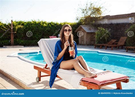 Beautiful Brunette Girl Drinking Cocktail Sitting Near Swimming Pool