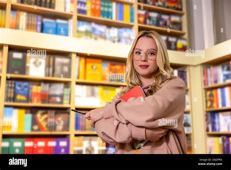 Pretty Blonde Woman Standing With Books In Library Stock Photo Alamy