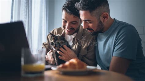 Feliz Pareja Gay Enamorada De Desayunar Sano Y Jugar Con Un Gatito Bello Alegre Foto De Archivo