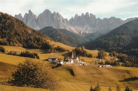 Hermoso pueblo en una colina de hierba seca rodeada por las montañas