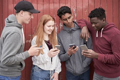 Grupo De Amigos Adolescentes Que Miran Los Tel Fonos M Viles En El