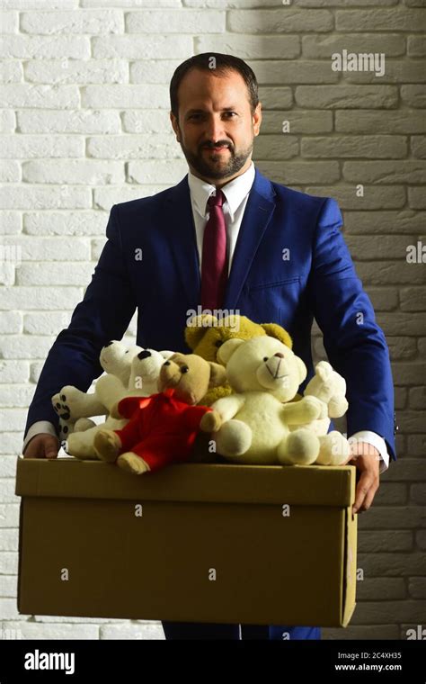 Businessman Wears Smart Suit And Tie Leader Holds Box Full Of Toys On