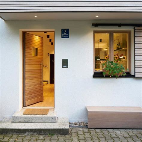 A White House With Wooden Doors And Steps Leading Up To The Front Door