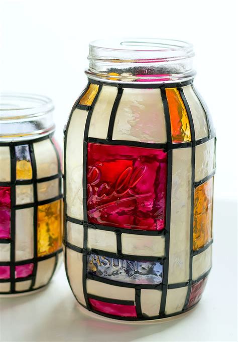 Two Glass Jars With Different Colored Designs On Them