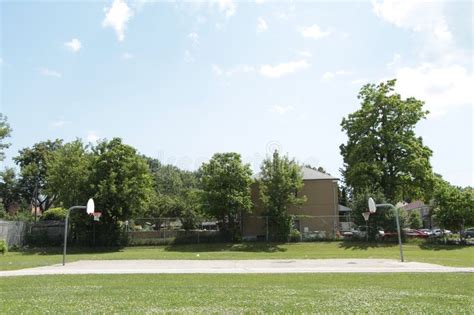 Outdoor Public Basketball Court Surrounded By Grass With Court Low In