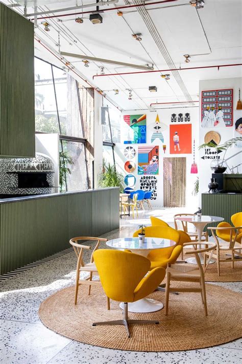 The Interior Of A Restaurant With Yellow Chairs And Tables