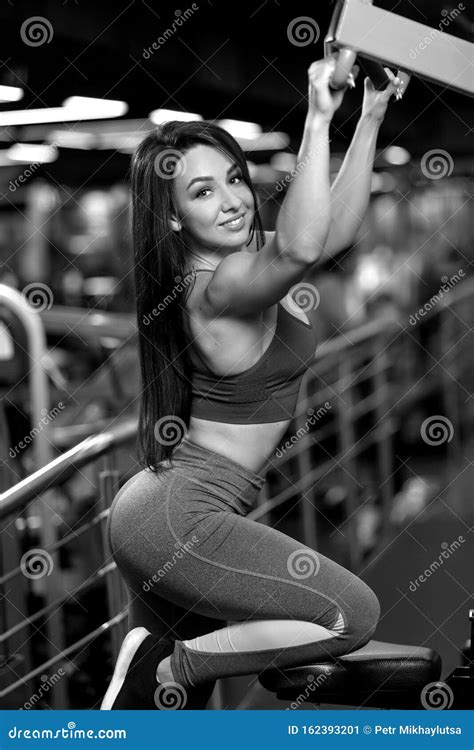 Fitness Brunette Girl Is Sitting And Doing Shoulder Exercises In Trainer Bw Stock Image Image