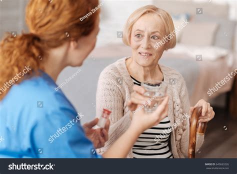 Focused Mature Woman Taking Required Medication Stock Photo 645693226