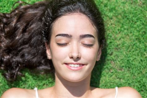 Alegre Rostro De Mujer Joven Descansando Sobre Hierba Foto Gratis