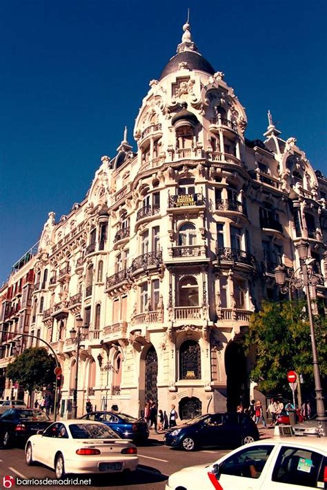 Cars Are Parked In Front Of An Ornate Building On The Corner Of A City