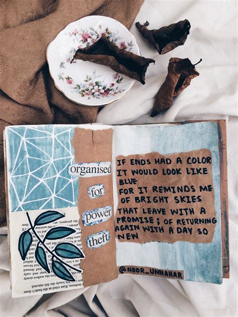 An Open Book On A Bed Next To Two Pieces Of Paper And Some Dried Leaves