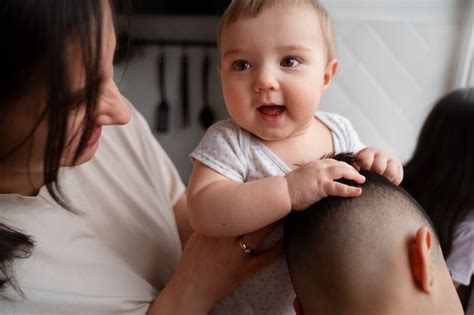 Vue latérale mère tenant un bébé mignon Photo Gratuite