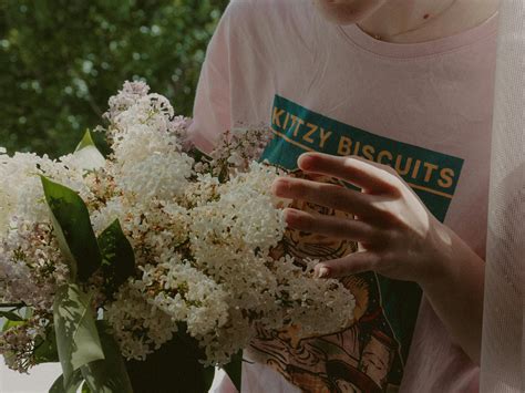 Photo of Woman's Hand Holding Out White Flowers In Front of White ...